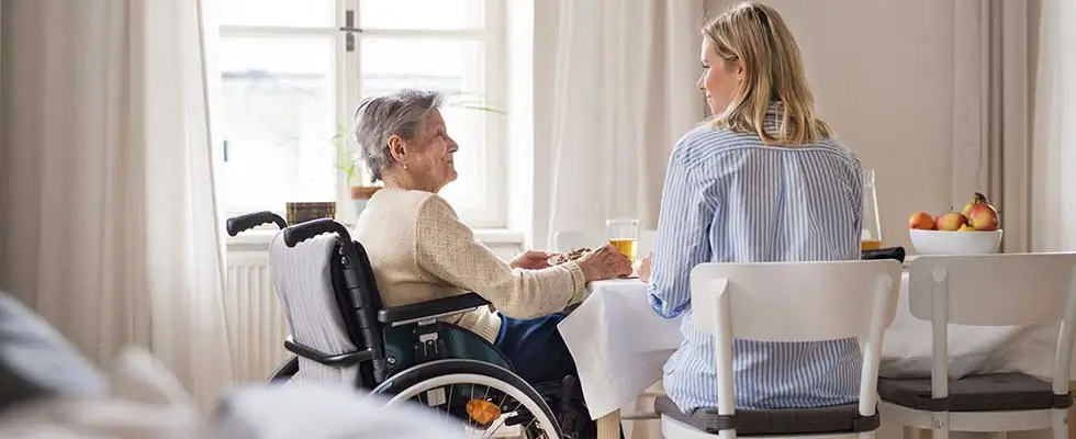 Smiling caregiver greeting senior client at home entrance in Liberty Hill