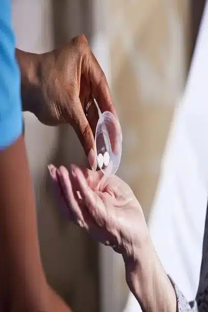 “Caregiver gently handing white pills to senior in a supportive home setting