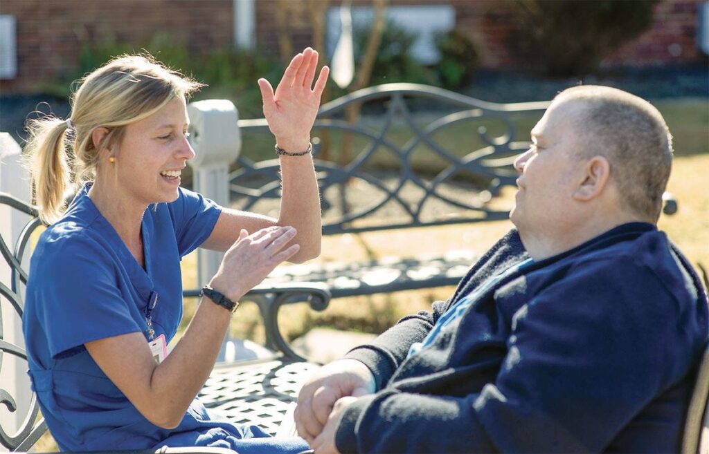 “Caregiver gently comforting elderly woman in peaceful home setting”
