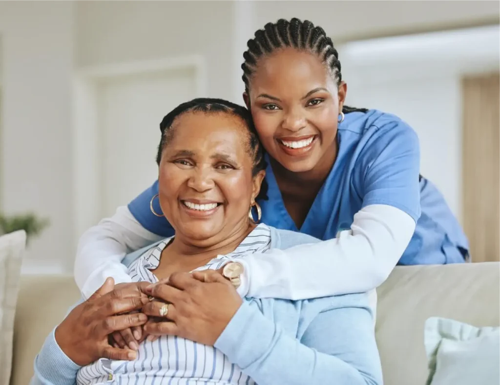 Two women smiling and hugging in a bright home setting.